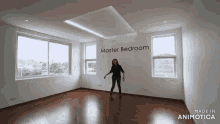 a woman is dancing in an empty room with a sign that says master bedroom