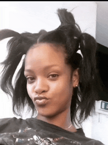 a close up of a woman 's face with pigtails on her hair