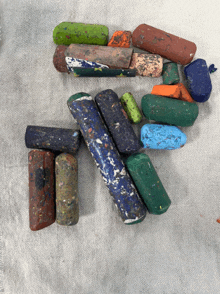 a bunch of crayons of different colors are laying on a table