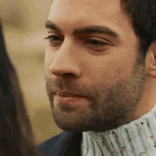 a man with a beard is looking at a woman .