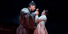 a man and a woman are dancing together in a dark room .