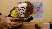 a person is holding a stuffed toy with a map of the united states in the background