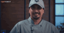a man wearing a top chef hat and a chef 's coat