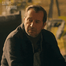a man sitting in a chair with saint-pierre written above him