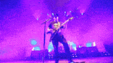 a man playing a guitar and singing into a microphone