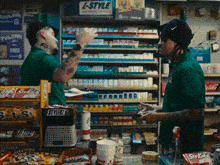 two men are working in a convenience store with a sign that says l-style on the wall behind them .