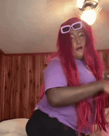 a woman with long red hair and sunglasses on her head
