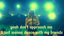 a woman singing into a microphone with the words yeah don 't approach me just wanna dance with my friends below her