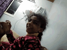 a woman in a pink pajama top is upside down in a room