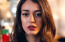 a woman with red lipstick on her lips looks at the camera