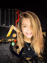 a girl is smiling in front of a bridge with the letter v in the foreground