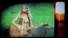 a woman is singing into a microphone while holding a guitar