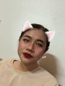 a woman wearing a cat ear mask with the letter ov on her cheek