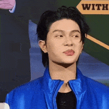 a man in a blue jacket is making a face with his tongue out .
