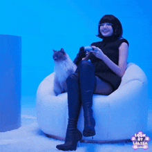a woman sits in a chair with a cat and a sign that says look at larisa