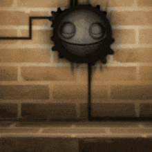 a brick wall with a black object with a face on it
