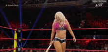 a woman in a wrestling ring holding a bat