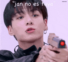 a close up of a person holding a gun with the words " jan no es tuya " on the bottom