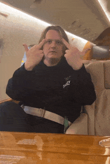 a man wearing a black shirt with the word sweet on it is giving the middle finger