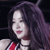 a woman with purple hair is wearing a choker and a red and white jersey