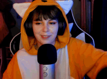 a woman wearing a fox costume and headphones is sitting in front of a microphone
