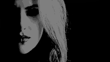 a black and white photo of a woman 's face with a nose ring and piercings .