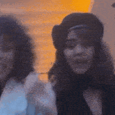 a woman wearing a beret is standing next to another woman wearing a beret .