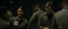 a man and a woman are shaking hands with a patch that says army on it