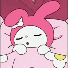 a pink bunny is sleeping on a bed with its eyes closed