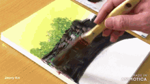 a person is painting a tree on a canvas with the words made in animatica on the bottom right