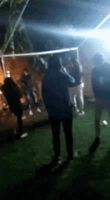 a group of people are standing in a dark room