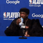 a man is drinking water from a bottle in front of a google logo