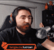 a man with a beard is wearing headphones and a t-shirt that says ' tongia.com '