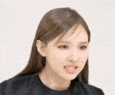 a close up of a woman 's face with a black shirt on .