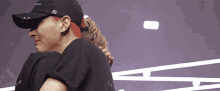 a man with red hair wearing a black hat is hugging another person