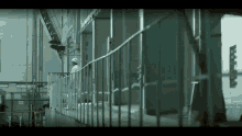 a man in a hard hat stands behind a metal railing