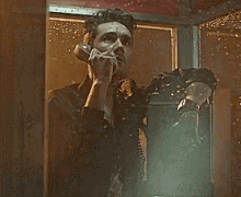 a man is talking on a pay phone in a booth