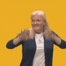 a woman wearing a shirt that says eversa holds her hands up