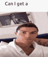 a man in a white robe is taking a selfie in front of a picture of a man and woman .