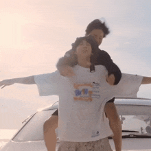 a man is carrying another man on his shoulders and the man is wearing a shirt that says ' altitude '