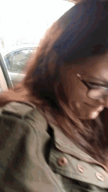 a close up of a woman wearing glasses and a jacket
