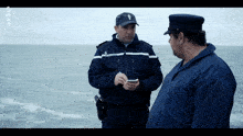 a man in a military uniform is talking to another man in a hat