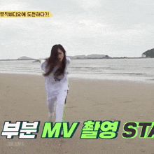 a woman is running on a beach with the words mv st7 in green letters behind her