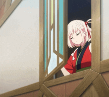 a girl in a red and black kimono looks out of a window