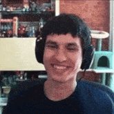 a man wearing headphones is smiling in front of a cat house