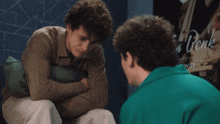 two men are talking in front of a poster that says denk