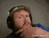 a man with a beard wearing headphones and a hat