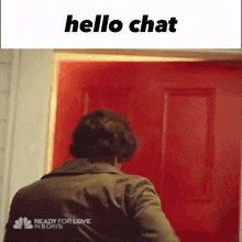 a man is standing in front of a red door and the words hello chat are above him