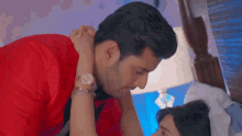 a man in a red shirt holds a woman 's hand