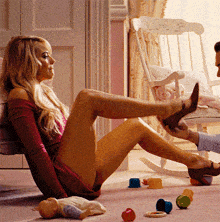 a woman sits on the floor with her legs crossed